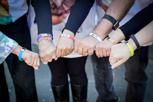 hands supporting one another nd wearing funeral bands in Leeds