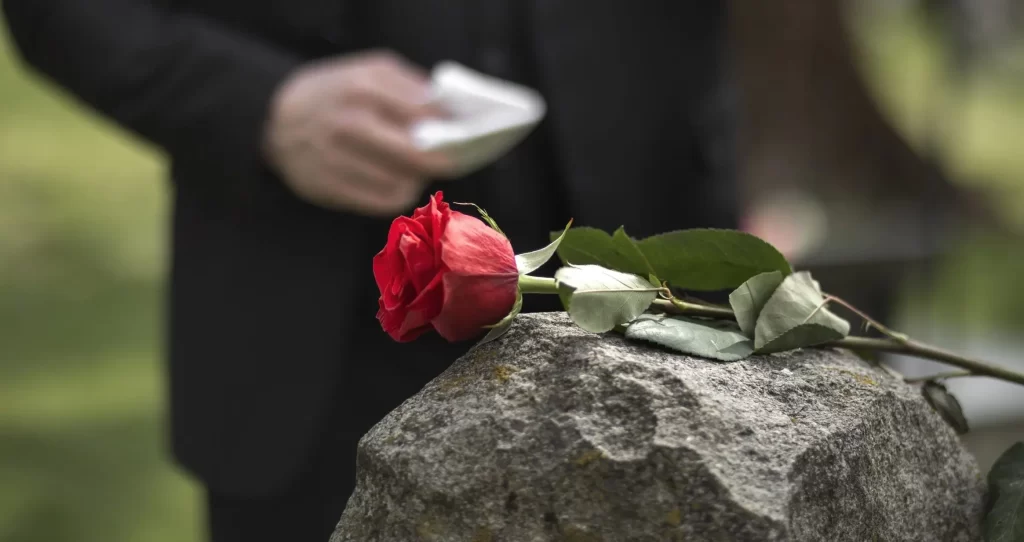 man paying respect tombstone cemetery | arranged by asian funeral homes